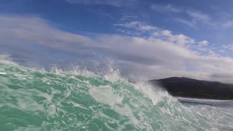 View-of-some-strong-rider-generating-some-speed-and-almost-doing-a-tube-in-Praia-do-Guincho,-Cascais,-Portugal