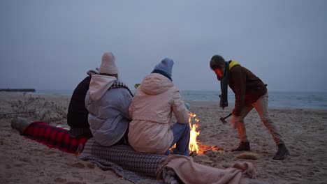 friends enjoying a bonfire on the beach at sunset