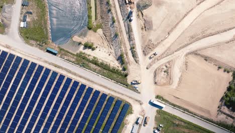 vista aérea de una instalación de paneles solares junto a un vertedero de residuos no reciclados