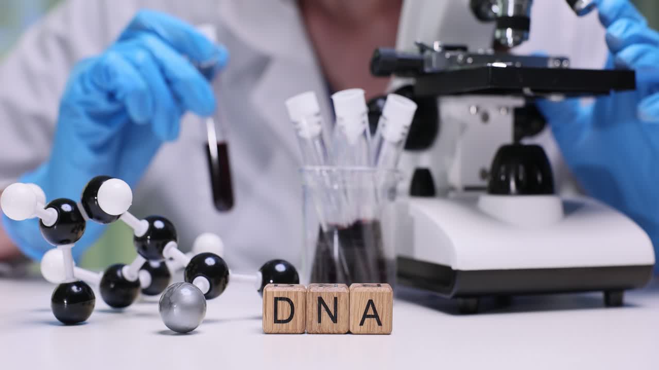 Scienziato che lavora con campioni di DNA e microscopio in laboratorio