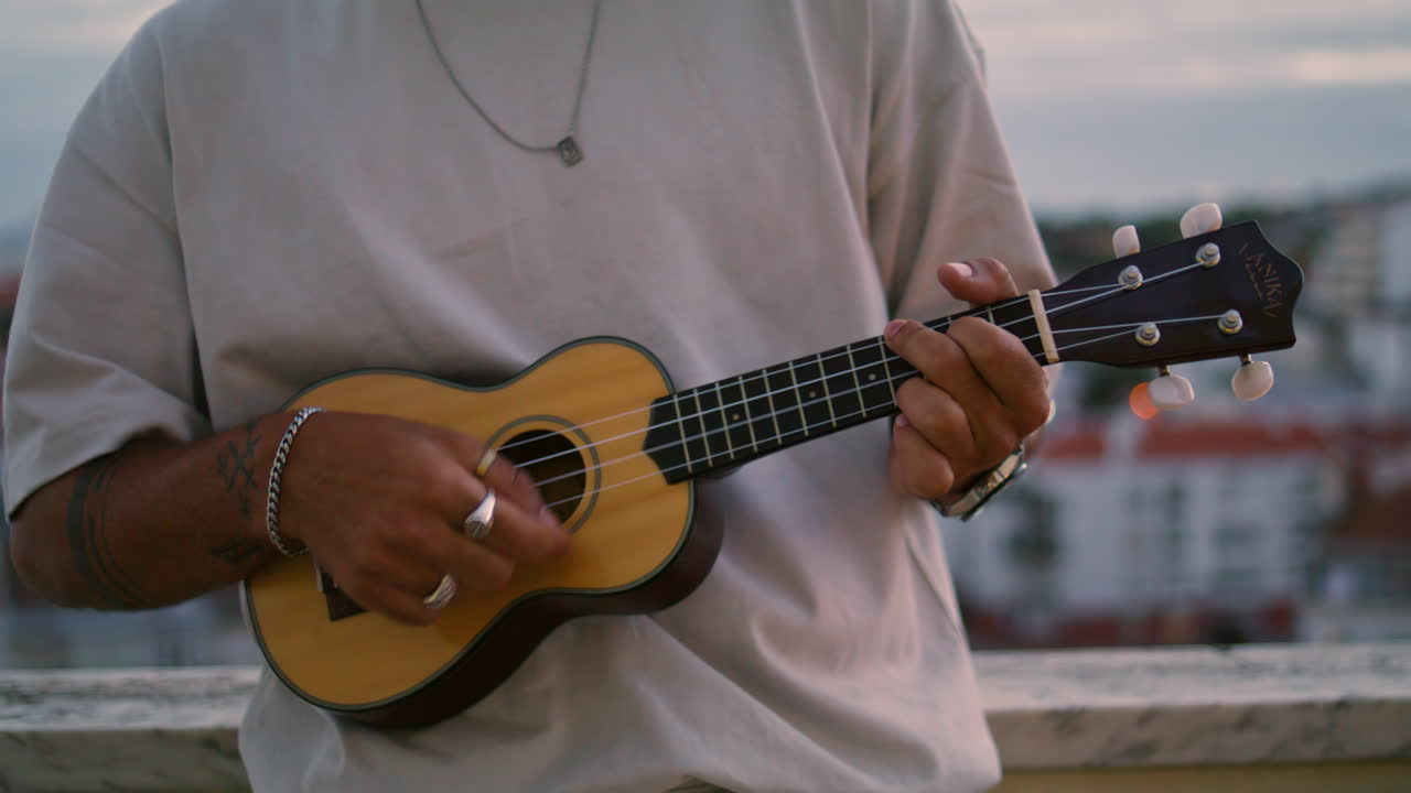 guitarrista desconocido tocando el ukulele lugar del atardecer. hombre satisfecho disfrutando de la música