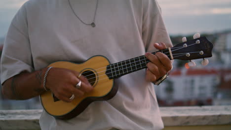 Unbekannter-Gitarrist-Spielt-Ukulele-Bei-Sonnenuntergang.-Zufriedener-Mann-Genießt-Musik