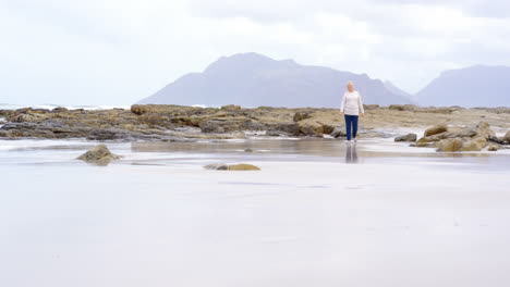 Front-view-of-old-caucasian-senior-woman-walking-at-beach-4k-