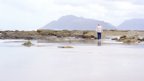 Vorderansicht-Einer-Alten-Kaukasischen-Seniorin,-Die-Am-Strand-Spaziert,-4k