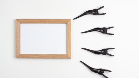 stop motion animation mockup marco de madera plano de cuatro secciones negras clips de cabello del sitio derecho de la plantilla de la imagen con espacio de copia en fondo blanco. concepto de equipo de peluquería