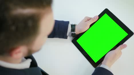 un hombre usando una tableta digital con una pantalla verde