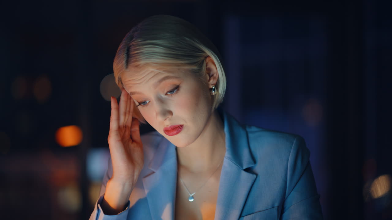 Night manager drinking coffee tired workplace portrait. Woman massaging temples