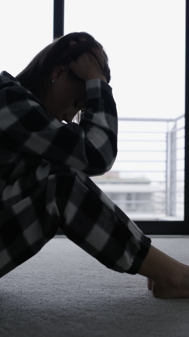 Young Woman Sitting on Floor Feeling Sad and Depressed