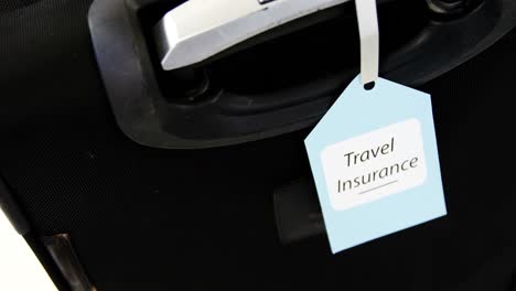 travel insurance label tied to a suitcase