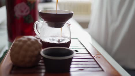 mesa portátil para la ceremonia del té. el té se vierte en la tetera a través de un embudo, saturando su sabor con oxígeno