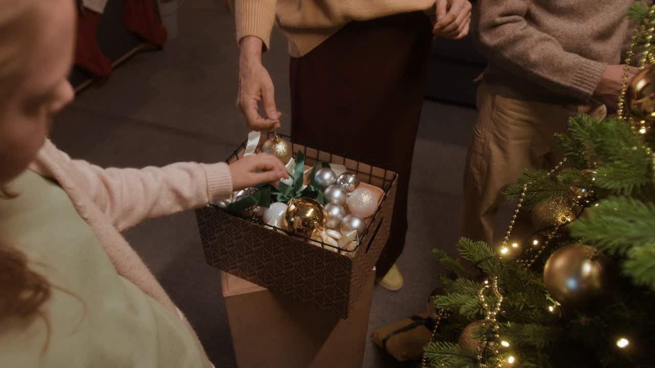 Family Decorating Christmas Tree with Ornaments