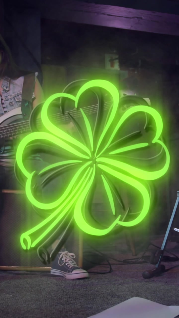 Animazione di un trifoglio verde al neon del giorno di San Patrizio su una donna che suona la chitarra sul palco