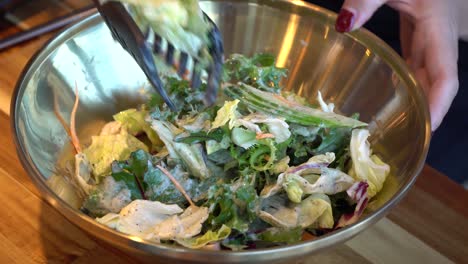 mezclar ensalada de lechuga con pepino y cebolla en un recipiente inoxidable - cerrar
