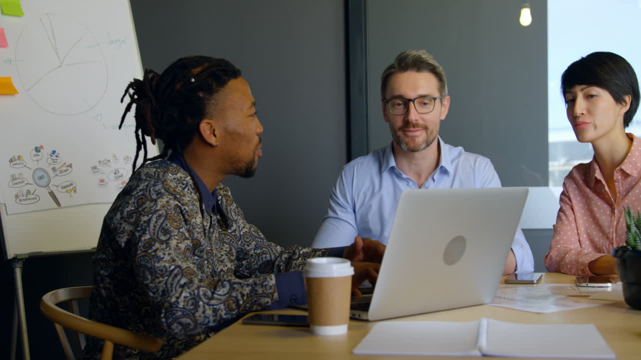 Business executives discussing over laptop in conference room 4k 