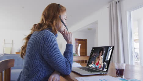 mujer caucásica usando portátil y auriculares de teléfono en videollamada con una colega
