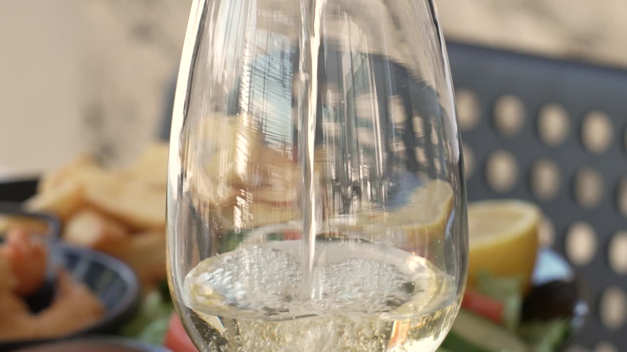 Enjoying a refreshing wine amidst vibrant culinary delights on a sunny terrace - Close Up Shot