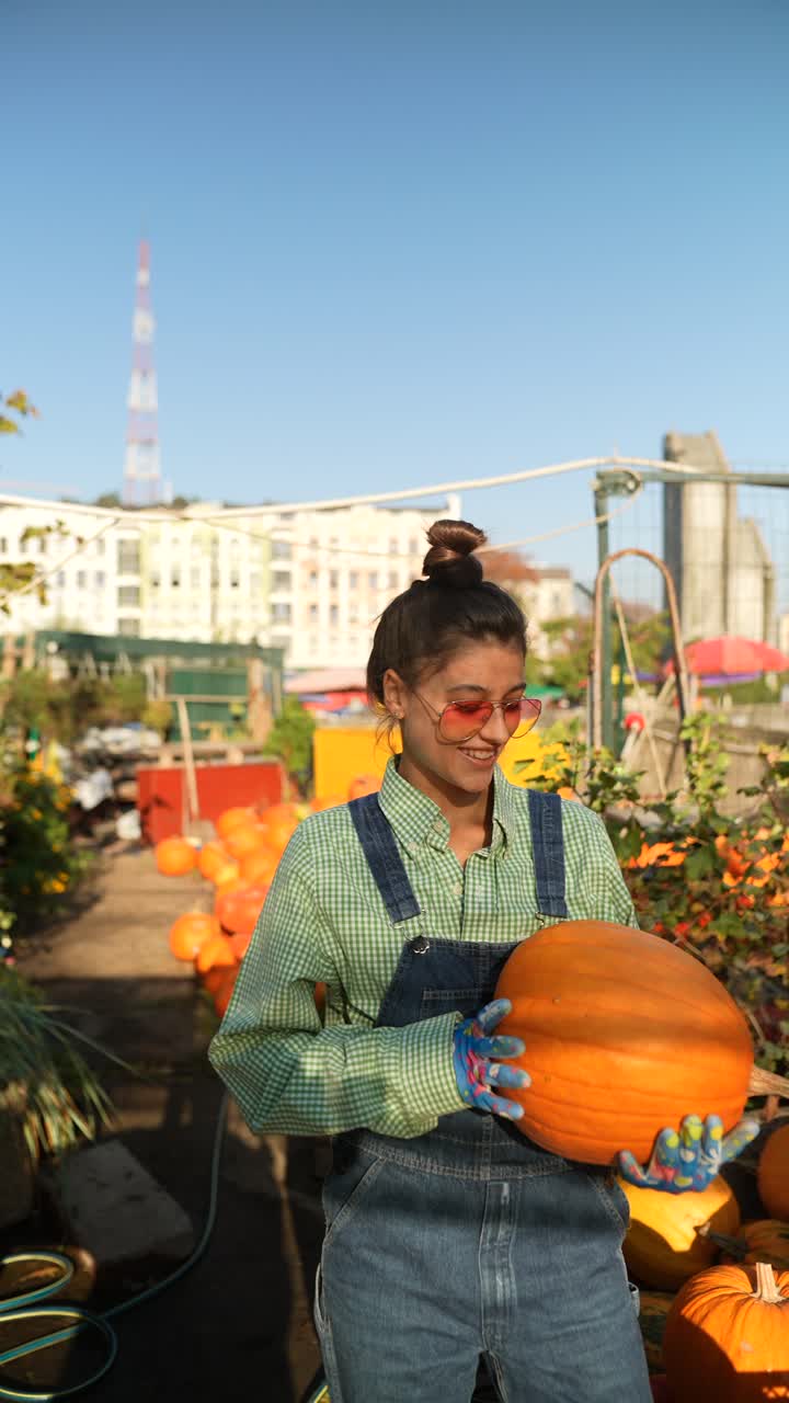 mujer sosteniendo una calabaza en un jardín urbano