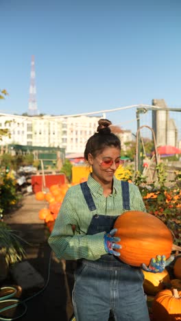 woman holding a pumpkin in an urban garden