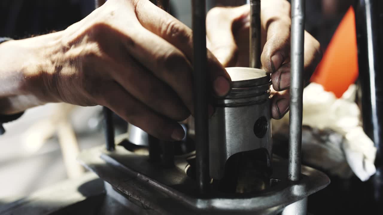 기계공이 고장난 엔진을 수리하고, 기계공이 오래된 오토바이 엔진을 고치고, 피스톤에 반지를 니다.