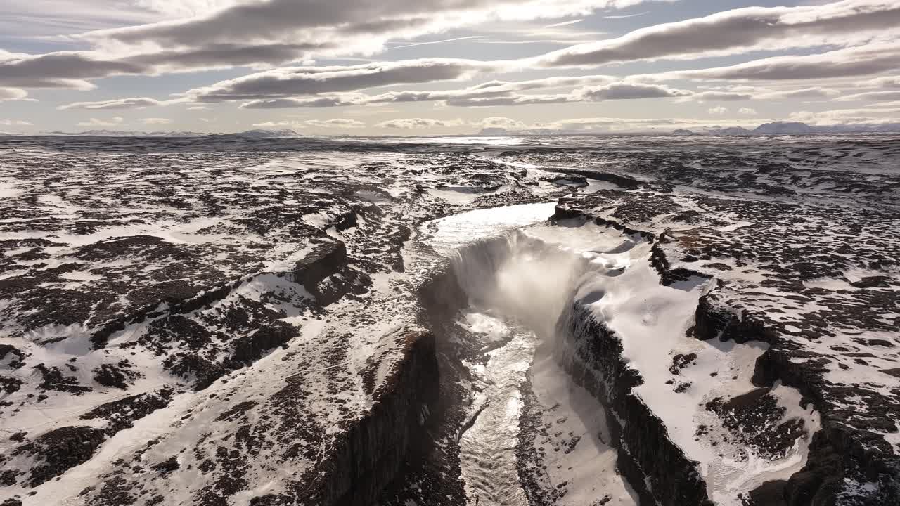 Drone view of Selfoss waterfall cutting through a snow-draped volcanic gorge. Selfoss, Iceland
