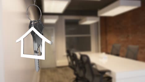 animation of hanging silver house keys against interior of a office conference room