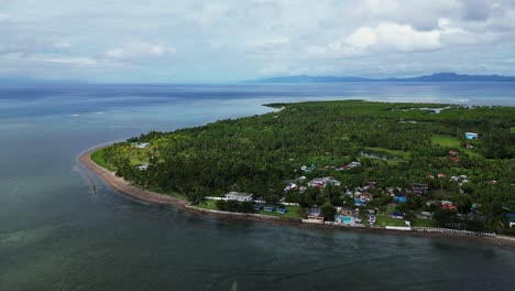 overhead aerial view of lush tropical island coast with quaint village and turquoise ocean waters in agojo, san andres, catanduanes