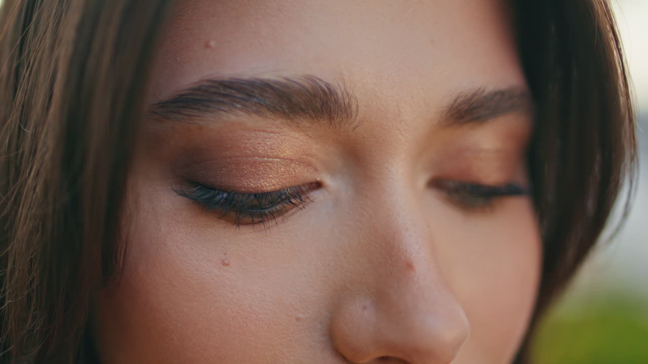 Closeup brunette eyes looking camera at nature. Green-eyed woman face portrait