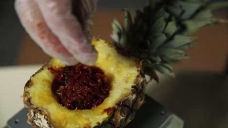 preparando un postre de piña con un relleno picante