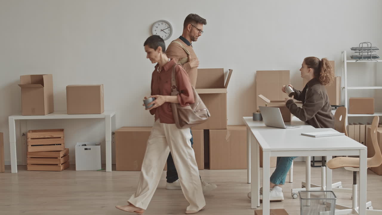People moving and packing boxes in an office