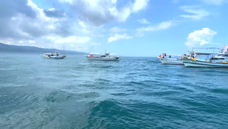 boats to transport tourists anchored in the bay floating in the sea with a beautiful blue sky and clouds waiting to watching dolphin in amakusa japan