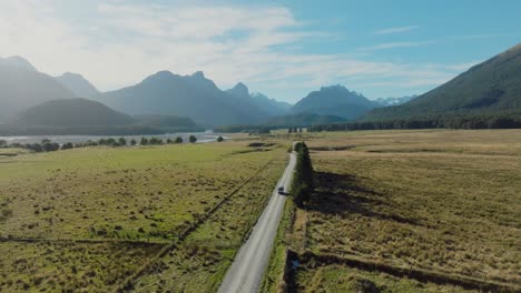 aerial view of tourist campervan driving through majestic landscape of dart valley in remote glenorchy, south island of new zealand aotearoa