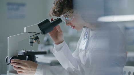 scientist using microscope and turning focus knob during examination