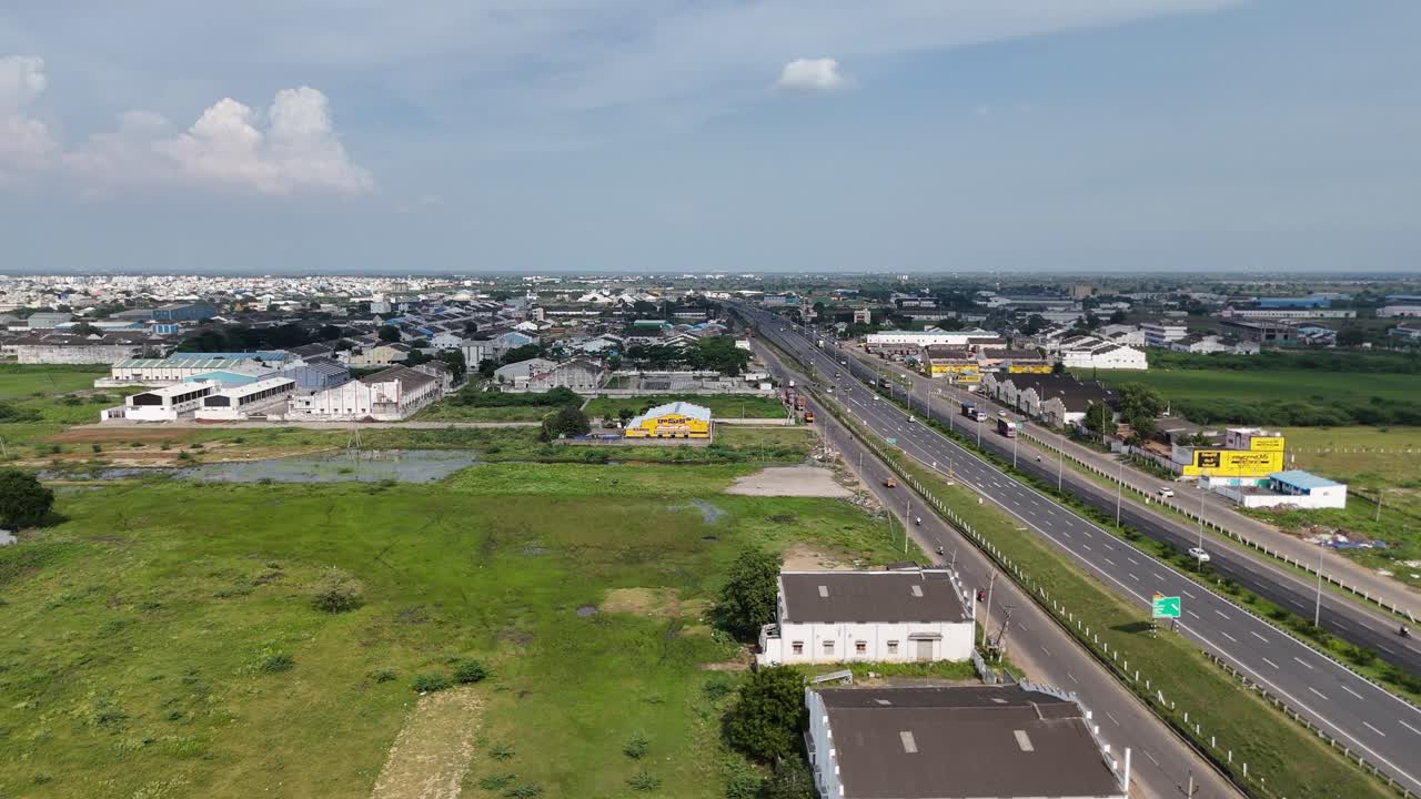 Wide-angle shot of Amaravathi’s countryside road surrounded by small building with greenery.