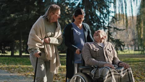 enfermera caminando con pacientes mayores en el parque