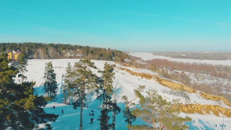 movimiento aéreo sobre montañas con esquiadores en el resort en invierno