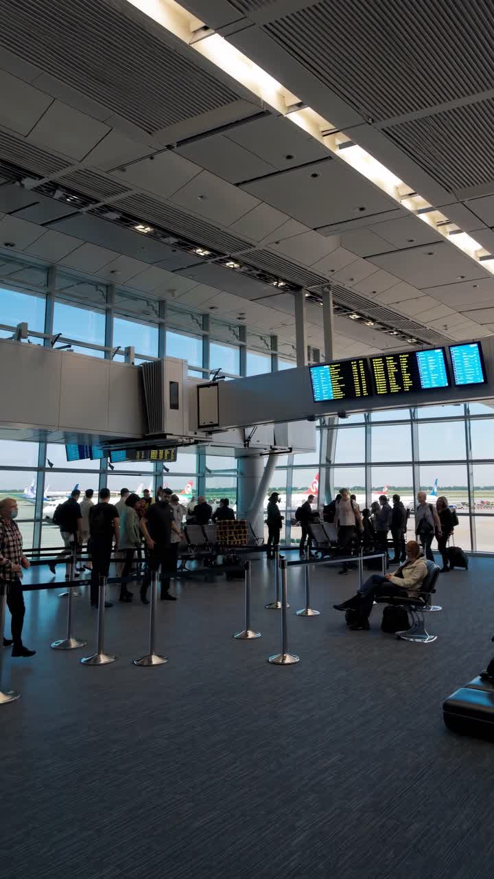 Wide-angle shot of an airport terminal with travelers queuing, emphasizing movement and travel