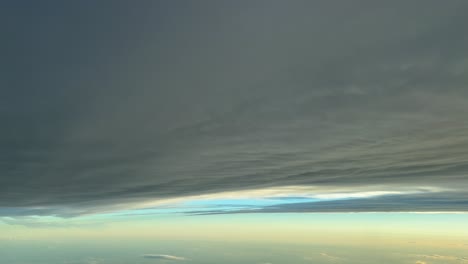 POV-Flug-Unter-Einer-Grauen-Schicht-Stratuswolken,-Aufgenommen-Aus-Dem-Cockpit-Eines-Jets