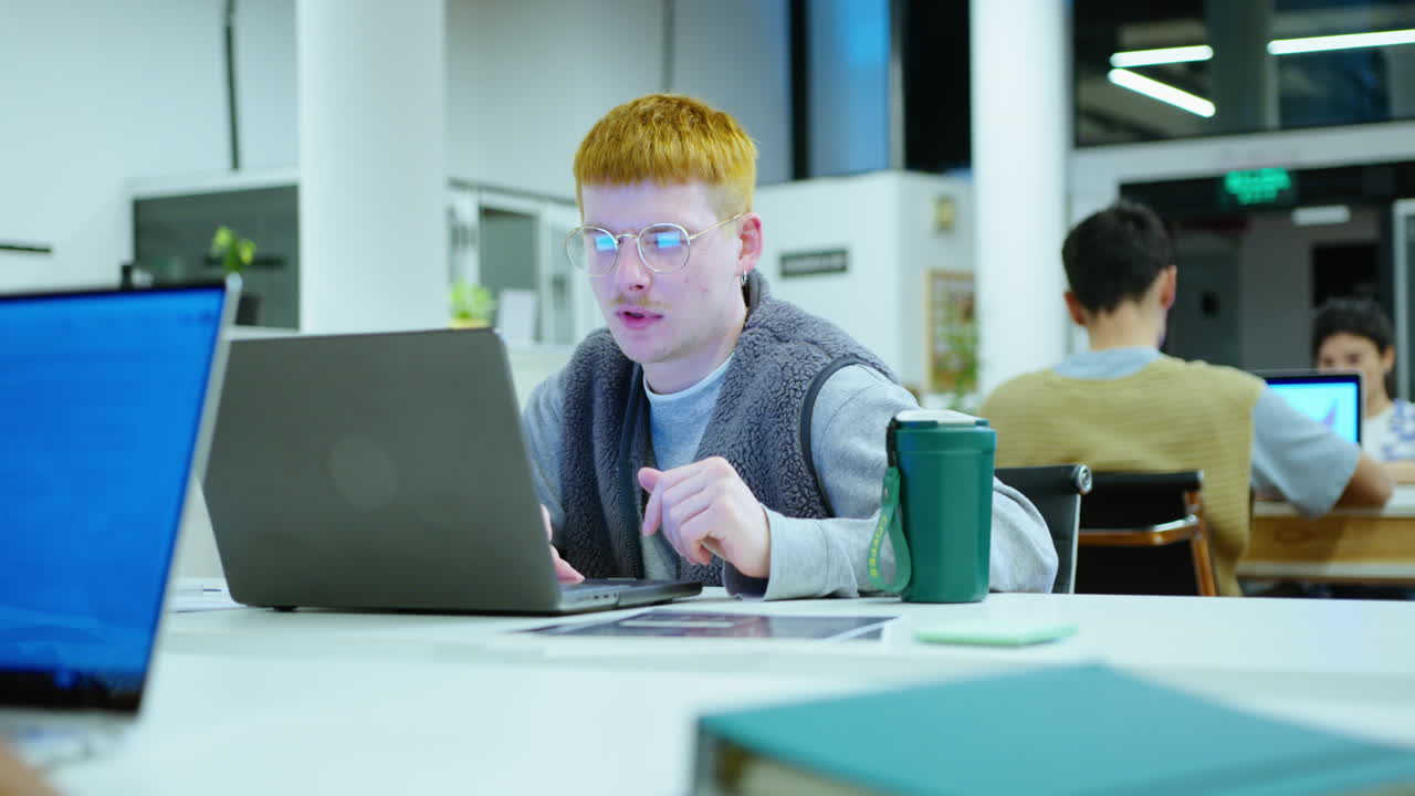 Young Male Office Worker Using Laptop at Desk