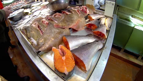 salmon, skate and whole pomfret fish are displayed in chinatown fish market.