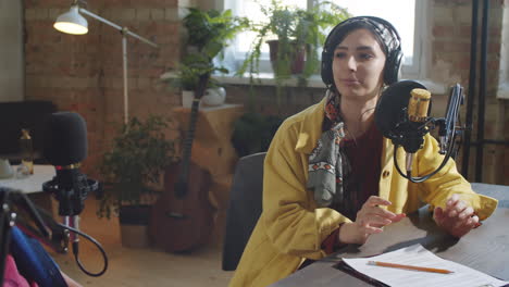 female podcaster interviewing guest in recording studio