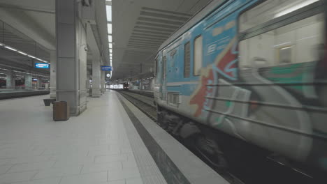 plataforma de la estación de tren vacía con tren de graffiti
