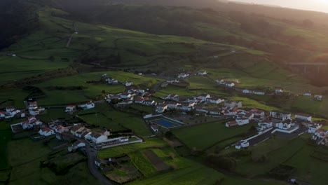 imágenes de drones del exuberante campo verde de la isla volcánica al atardecer con casas de techo naranja en las azores isla de sao miguel