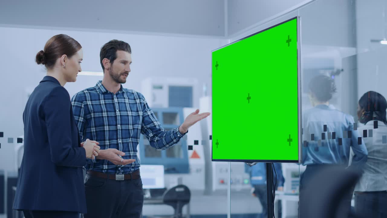 ingeniera informática y gerente de proyecto masculino usan una pizarra digital interactiva que muestra una pantalla verde. los desarrolladores encuentran la solución del problema. sala de reuniones de fábrica moderna