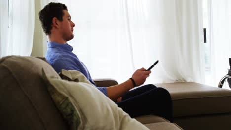 hombre discapacitado viendo televisión en el sofá 4k