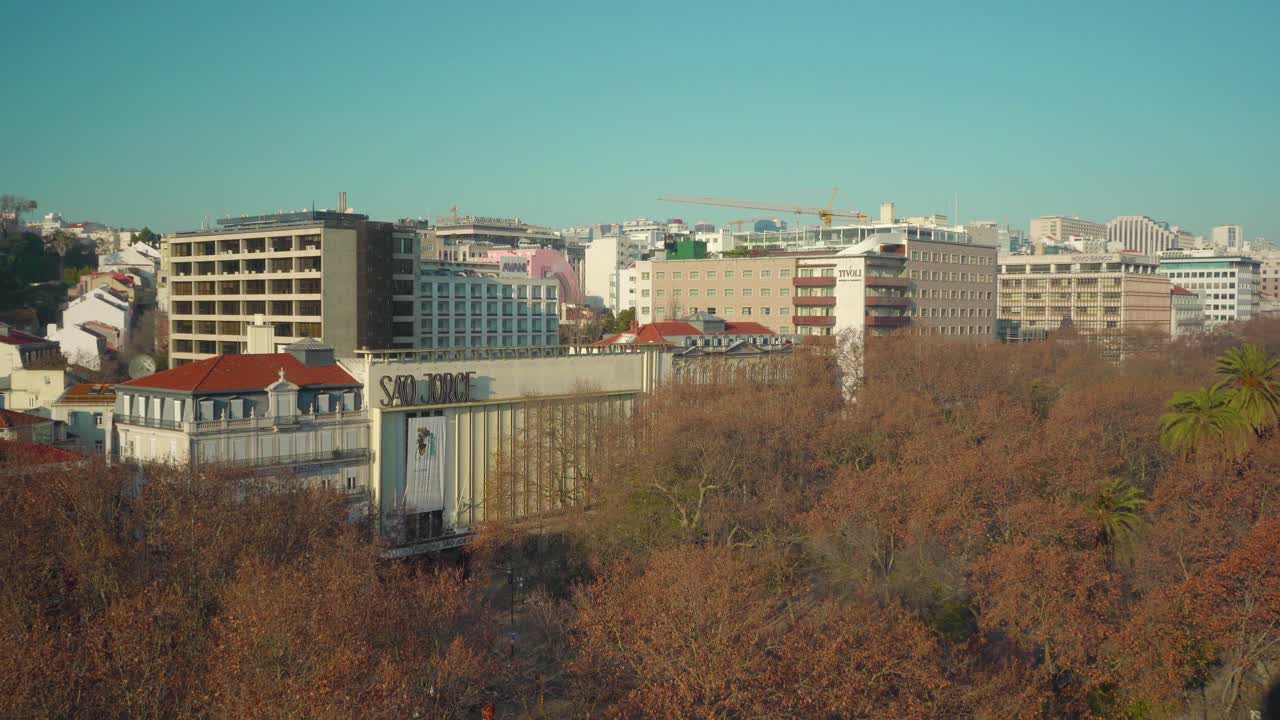 azotea de la ciudad de lisboa al amanecer bajo el cielo azul sobre los árboles tiro amplio 4k