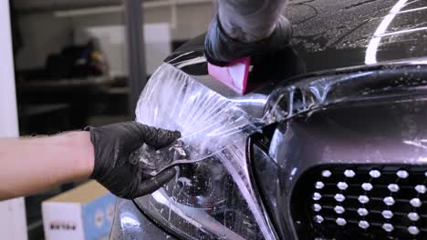 man covering car with vinyl polyurethane tape. films for the car. sticker protective film on the car