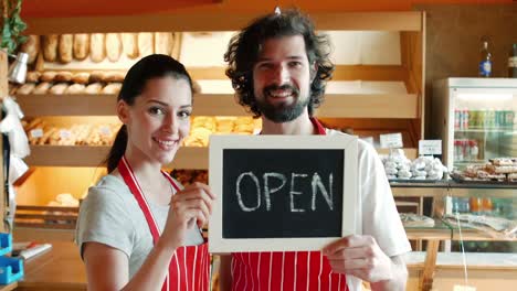 bakers holding open signboard