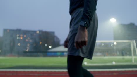 soccer player walking on the track at night