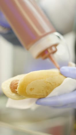 Adding sauce to a hot dog