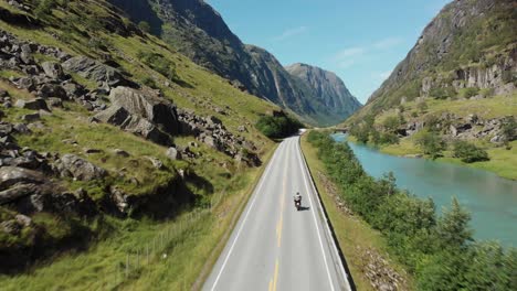 a motoclyce is driving away on an awasome road in norway